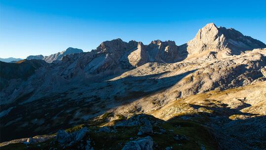 Mountain shaded on one side, the summit illuminated by the sun